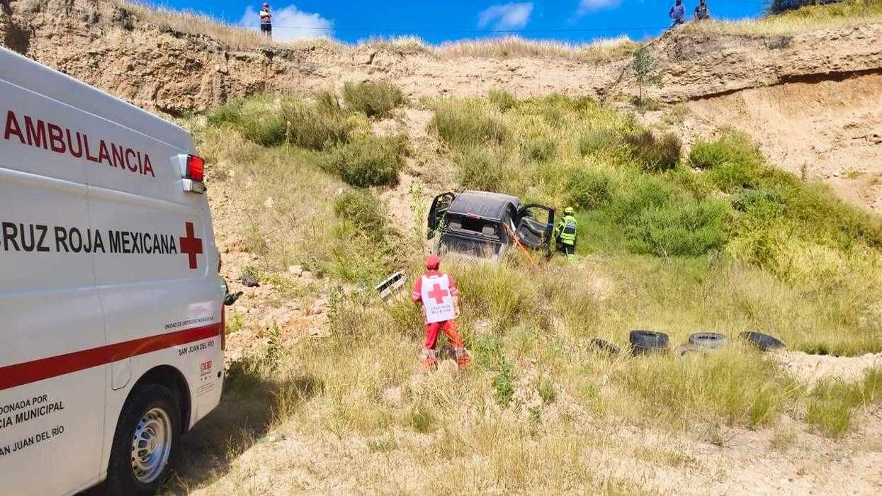 Camioneta pick up sobre sus llantas en la ladera de un banco de tepetate, con una ambulancia de la Cruz Roja Mexicana y personal de emergencia en el lugar.