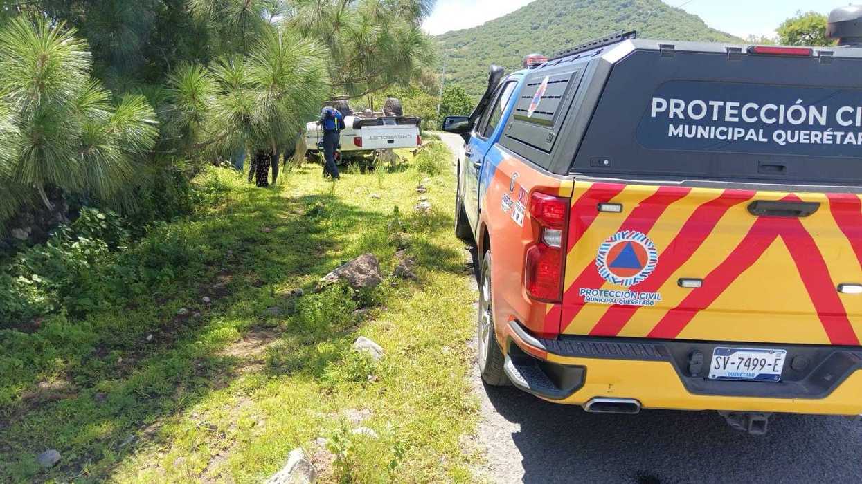 Camioneta volcada a un costado del camino mientras personal de Protección Civil atiende el accidente en Casa Blanca, Querétaro.