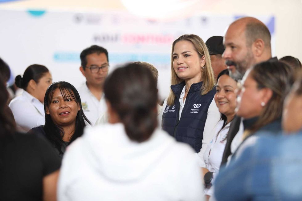 Car Herrera de Kuri sostiene arreglo floral artesanal durante el Tercer Encuentro Regional de Grupos de Desarrollo Comunitario en Pe\u00f1amiller, Quer\u00e9taro, 2026