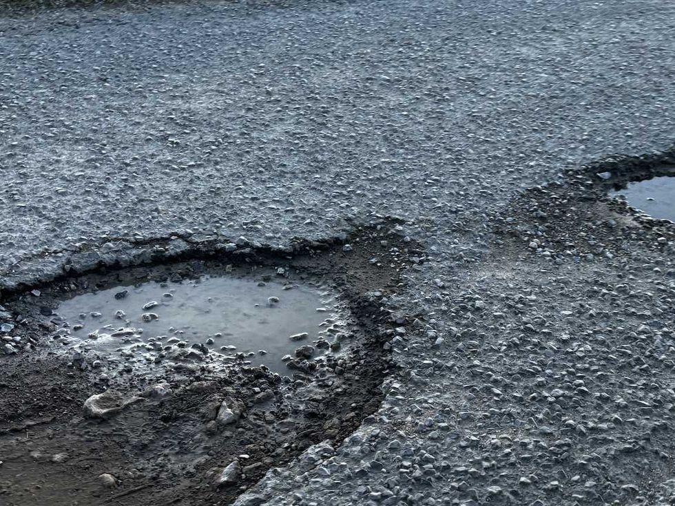 Carretera de Nopala de Villagr\u00e1n con dos baches profundos llenos de agua y pavimento roto durante la temporada de lluvias.
