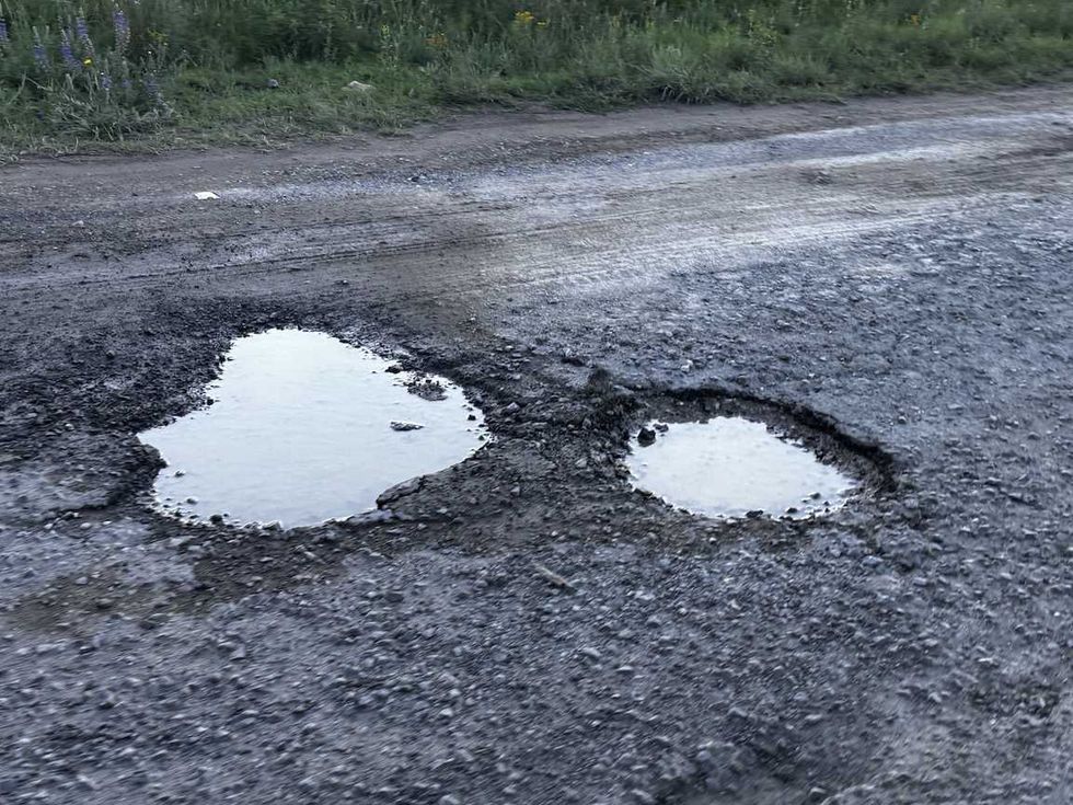 Carretera de Nopala de Villagr\u00e1n con dos baches profundos llenos de agua y pavimento roto durante la temporada de lluvias.