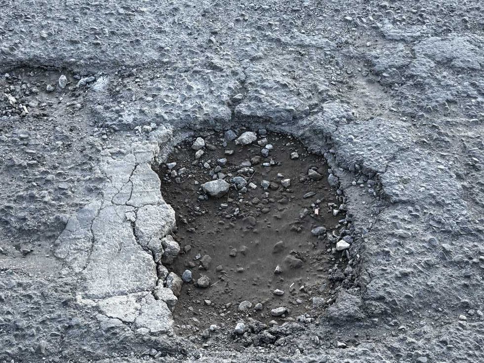 Carretera de Nopala de Villagr\u00e1n con dos baches profundos llenos de agua y pavimento roto durante la temporada de lluvias.