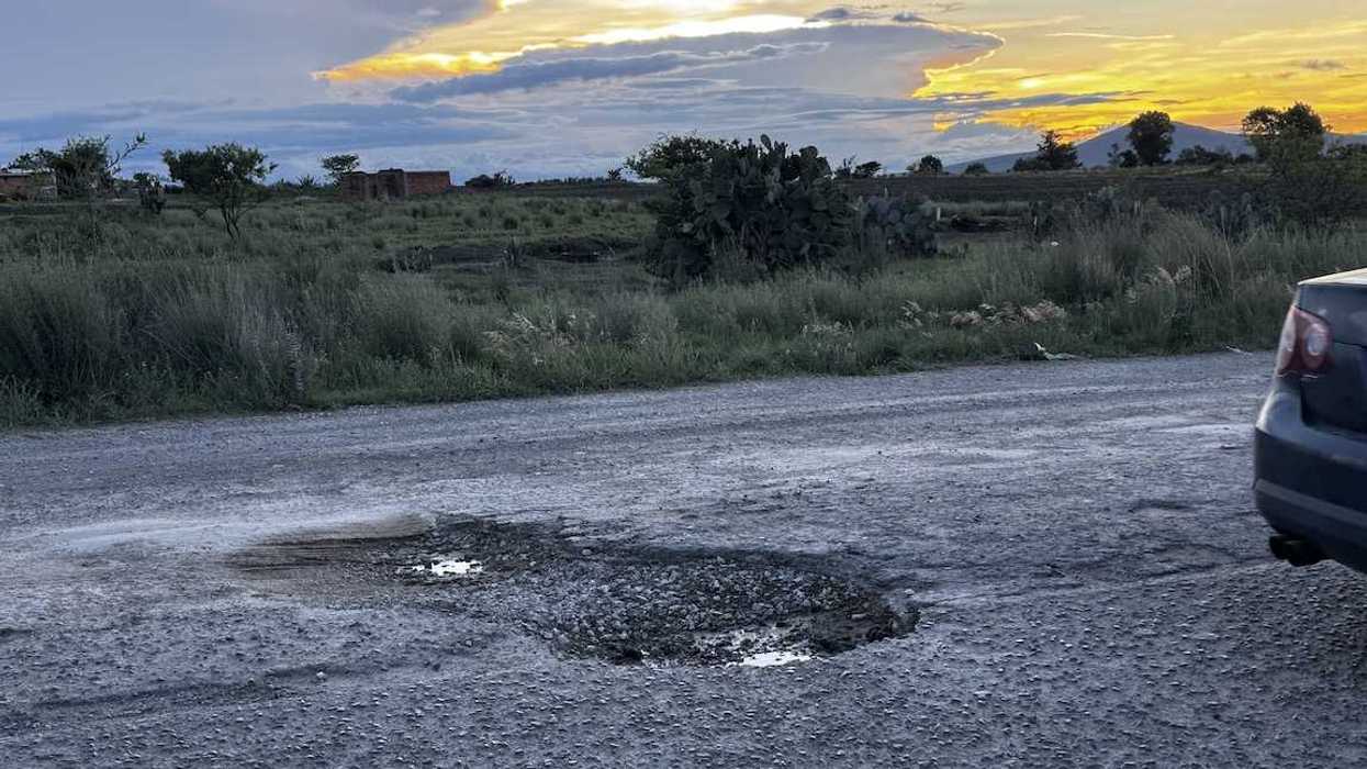 Carretera de Nopala de Villagrán con dos baches profundos llenos de agua y pavimento roto durante la temporada de lluvias.