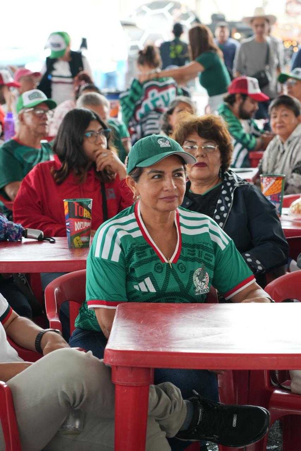 Cientos de aficionados observan un partido del Mundial en la pantalla gigante del M\u00e9xicQ Zona Fest, bajo banderas de distintos pa\u00edses