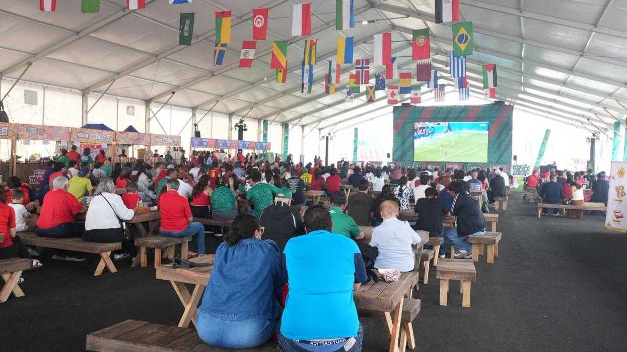 Cientos de aficionados observan un partido del Mundial en la pantalla gigante del MéxicQ Zona Fest, bajo banderas de distintos países