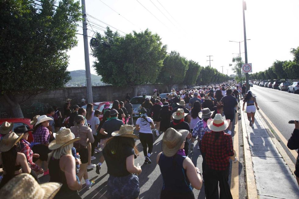 Cientos de participantes con sombreros vaqueros avanzan por una avenida del centro de San Juan del R\u00edo en el FestiVaqueRun 2026