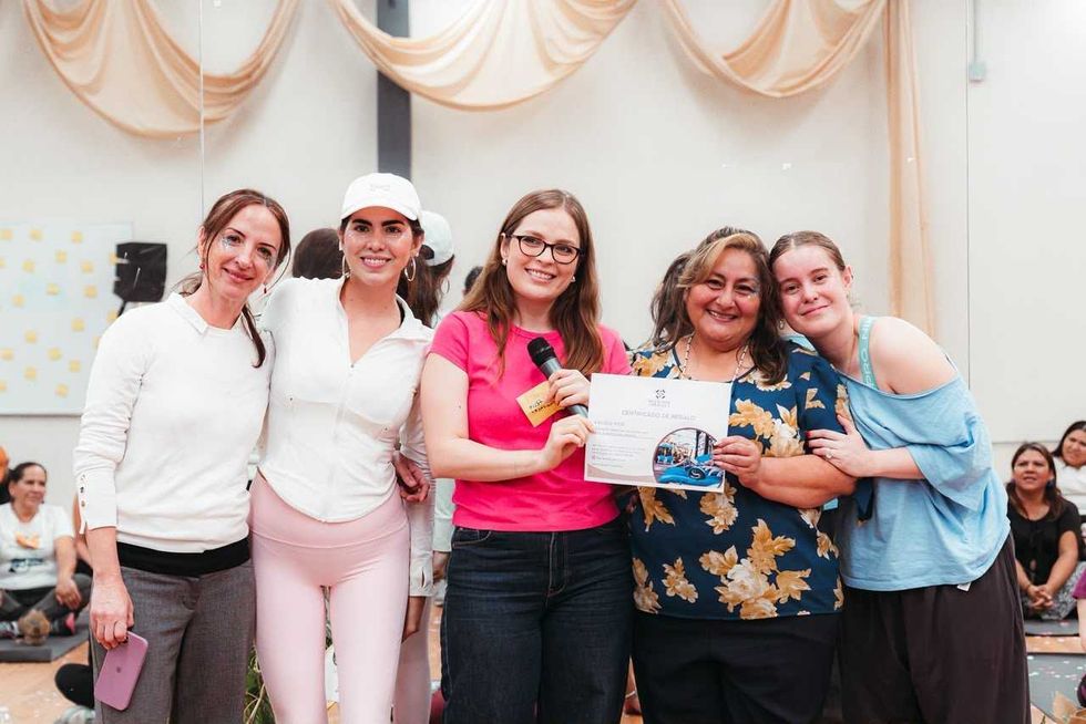 Cinco mujeres posan con un certificado de regalo y un micr\u00f3fono en una actividad del Centro de Empoderamiento en Quer\u00e9taro