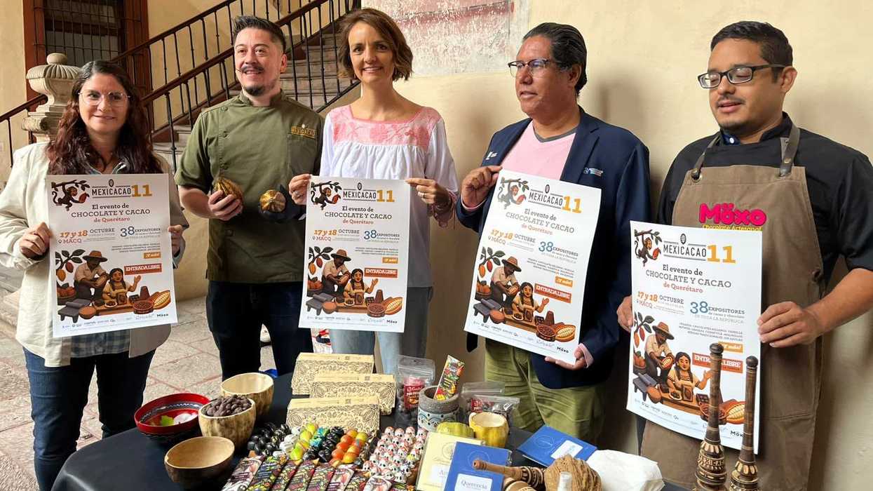 Cinco personas sostienen carteles de Mexicacao Querétaro junto a una mesa con barras de chocolate y granos de cacao