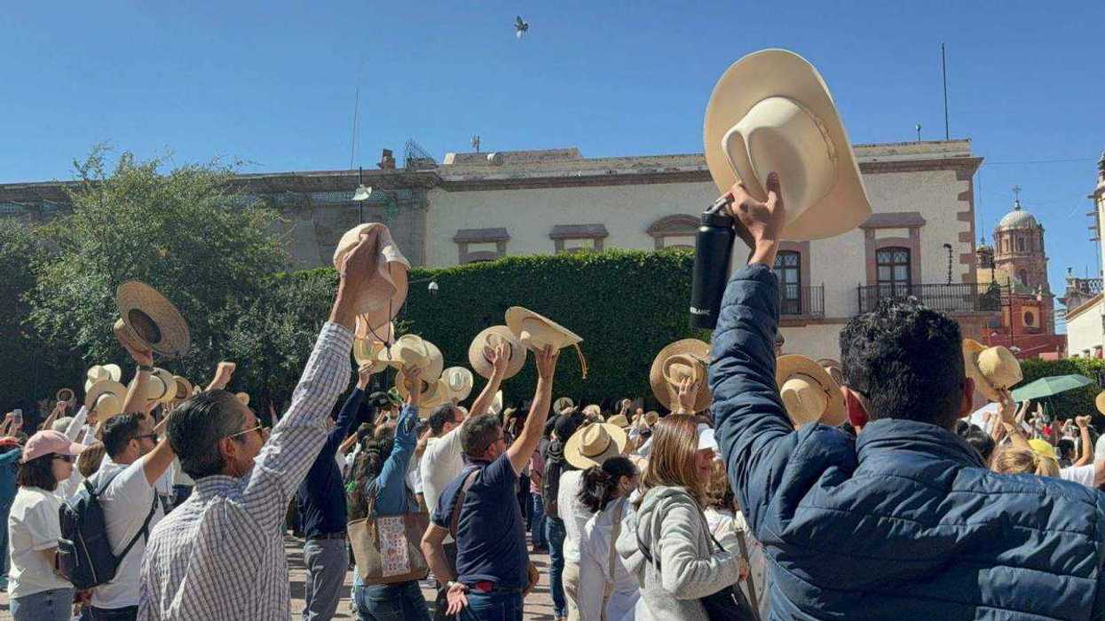 Ciudadanos reunidos en Plaza de Armas de Querétaro portando pancartas y sombreros durante manifestación por seguridad.