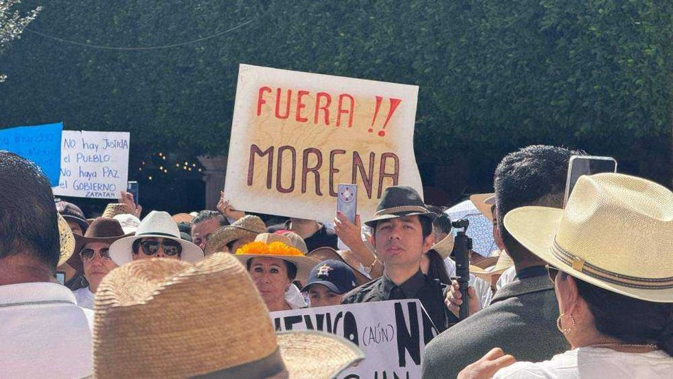 Ciudadanos reunidos en Plaza de Armas de Querétaro portando pancartas y sombreros durante manifestación por seguridad.