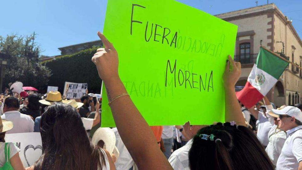 Ciudadanos reunidos en Plaza de Armas de Querétaro portando pancartas y sombreros durante manifestación por seguridad.