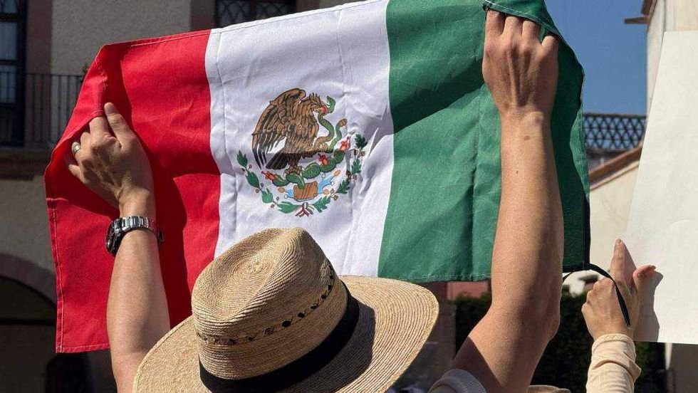 Ciudadanos reunidos en Plaza de Armas de Querétaro portando pancartas y sombreros durante manifestación por seguridad.