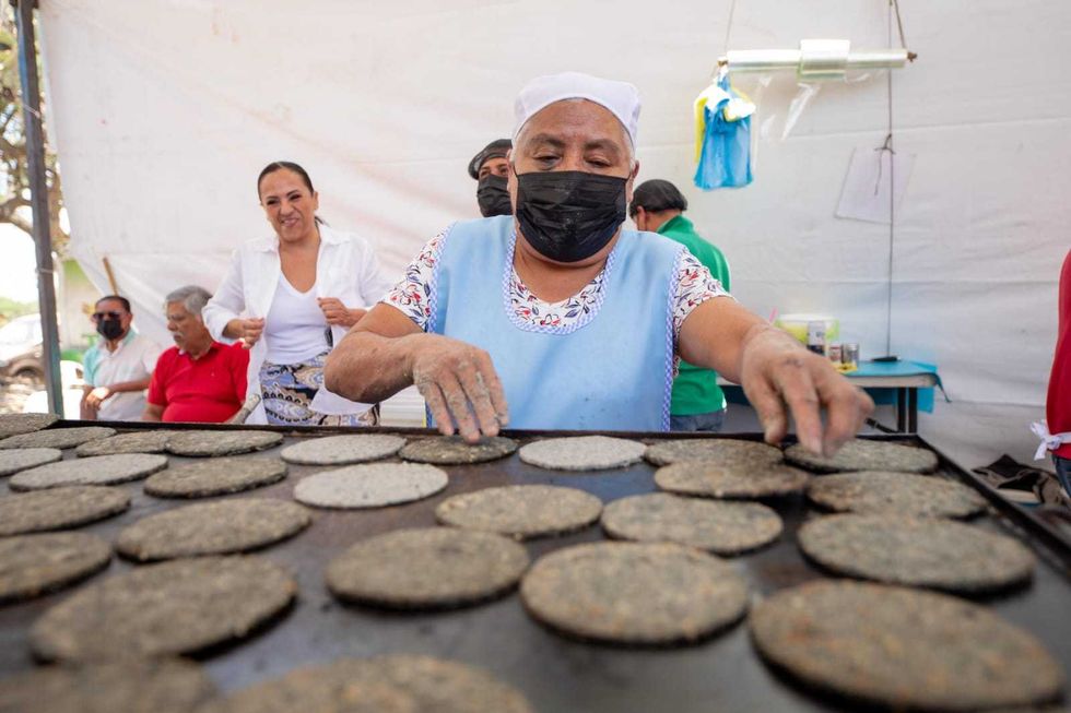 Cocineras tradicionales atienden gorditas y dobladitas en comal de le\u00f1a durante el quinto Festival de la Gordita en El Carrizo, San Juan del R\u00edo