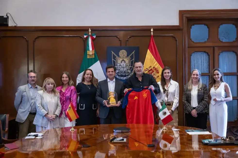 Comitiva de funcionarios espa\u00f1oles y queretanos posa con obsequios institucionales durante la reuni\u00f3n en Palacio de Gobierno