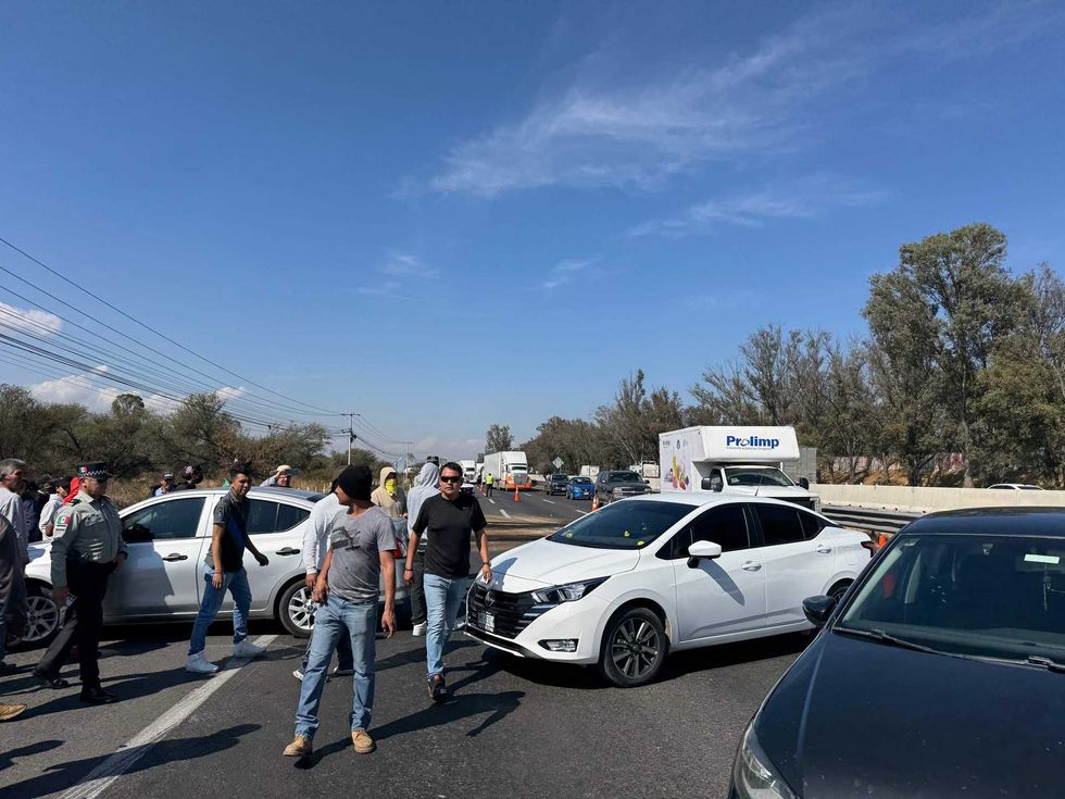 Conductores de Uber bloquean autopista México-Querétaro en San Gil, San Juan del Río, con vehículos y llantas quemadas.