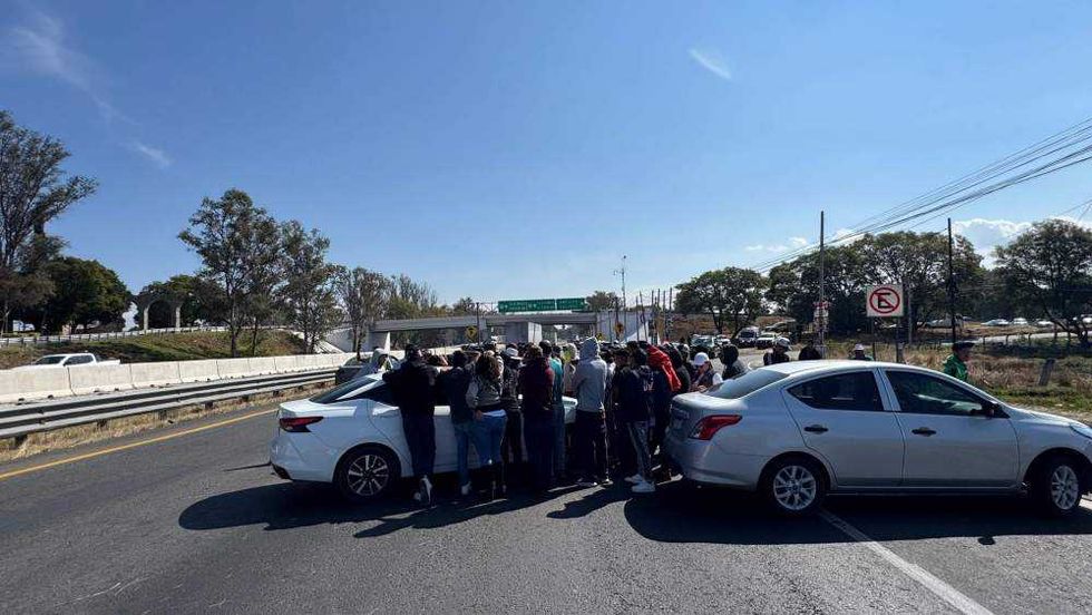 Conductores de Uber bloquean autopista México-Querétaro en San Gil, San Juan del Río, con vehículos y llantas quemadas.