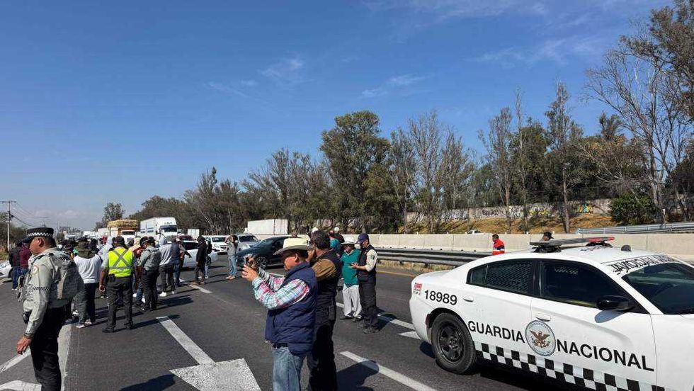Conductores de Uber bloquean autopista México-Querétaro en San Gil, San Juan del Río, con vehículos y llantas quemadas.