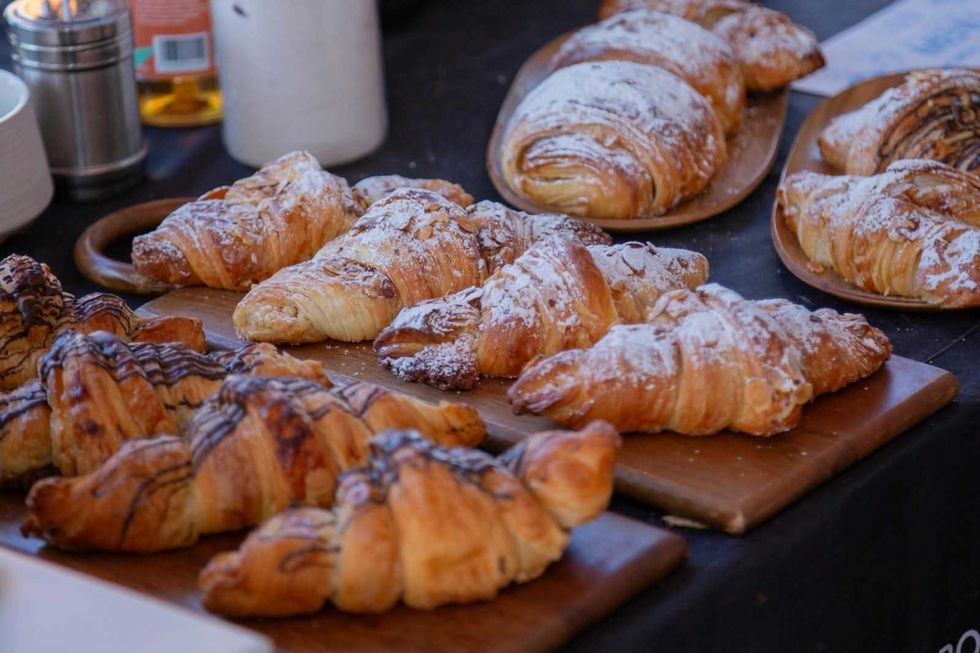 Croissants con almendra y chocolate sobre tablas de madera en un puesto de pan del Festival del Caf\u00e9 en San Juan del R\u00edo.