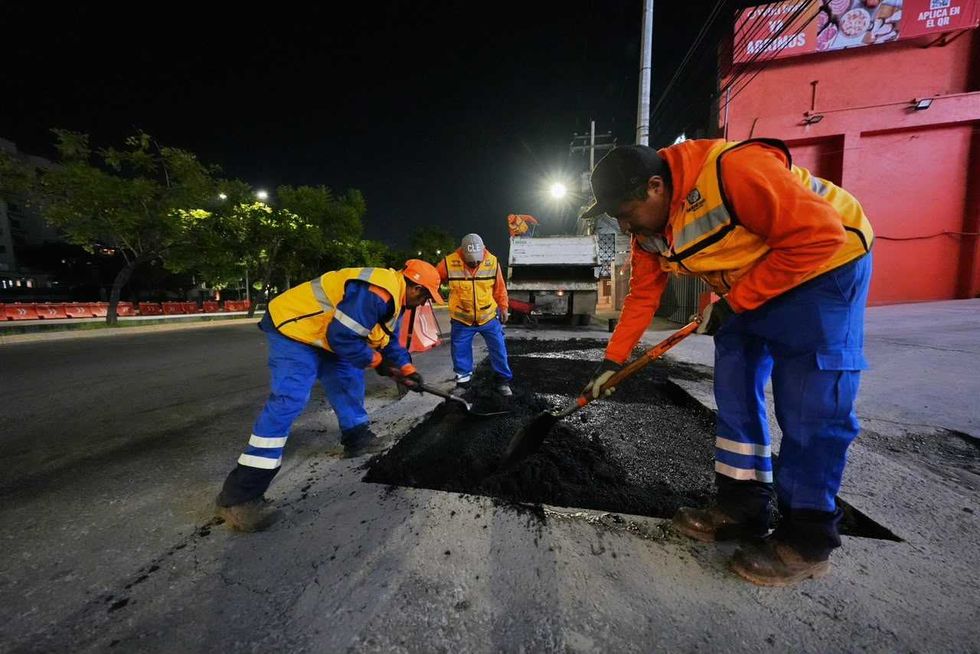 Cuadrilla con palas y dos hombres junto a un cami\u00f3n de volteo y un bache rellenado con asfalto en Quer\u00e9taro