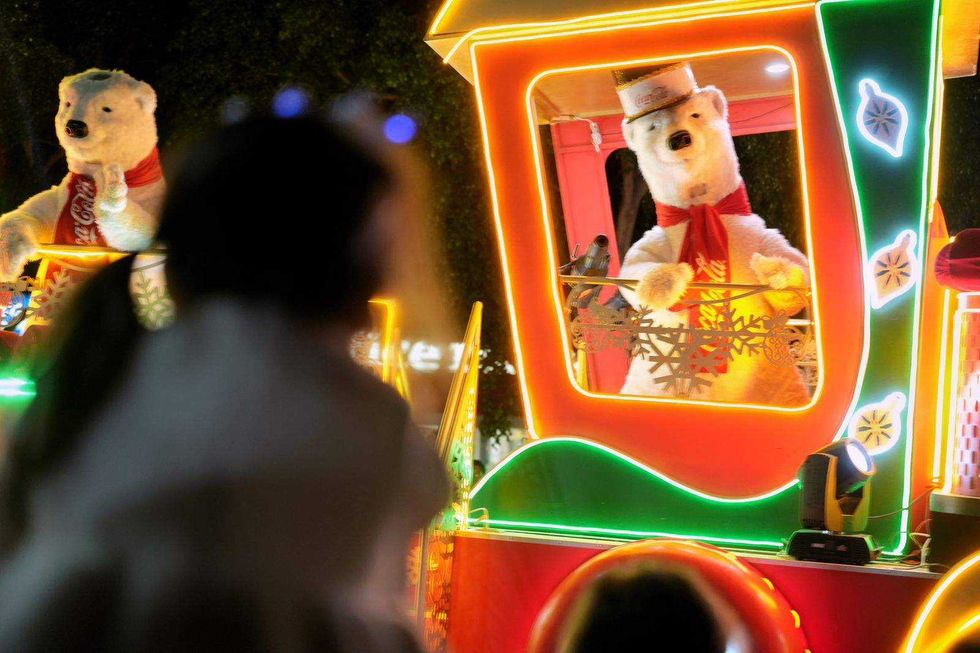 Desfile de Caravana Coca-Cola recorre calles de Santiago de Querétaro con carros alegóricos durante inauguración festividades decembrinas.