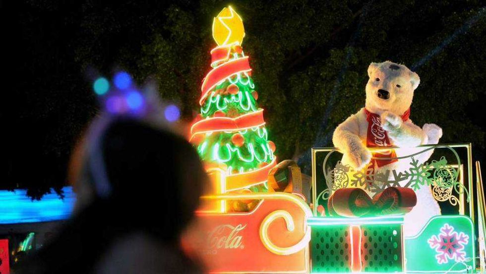 Desfile de Caravana Coca-Cola recorre calles de Santiago de Querétaro con carros alegóricos durante inauguración festividades decembrinas.