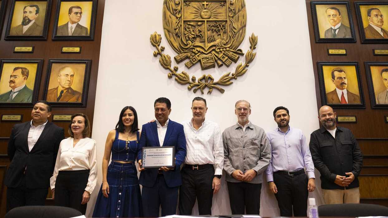 Detalle de manos sobre documento durante ceremonia institucional en Querétaro