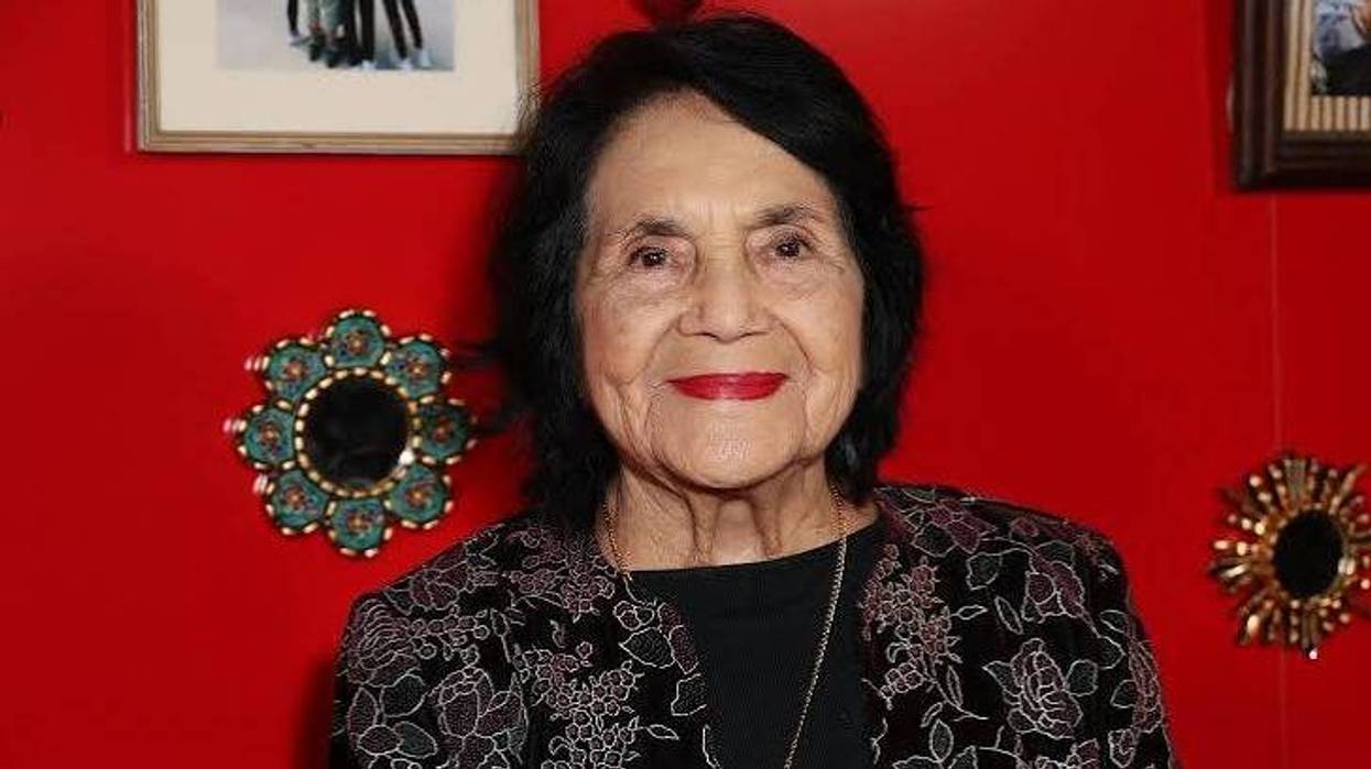 Dolores Huerta, cofundadora de United Farm Workers, con chaqueta floral frente a una pared roja