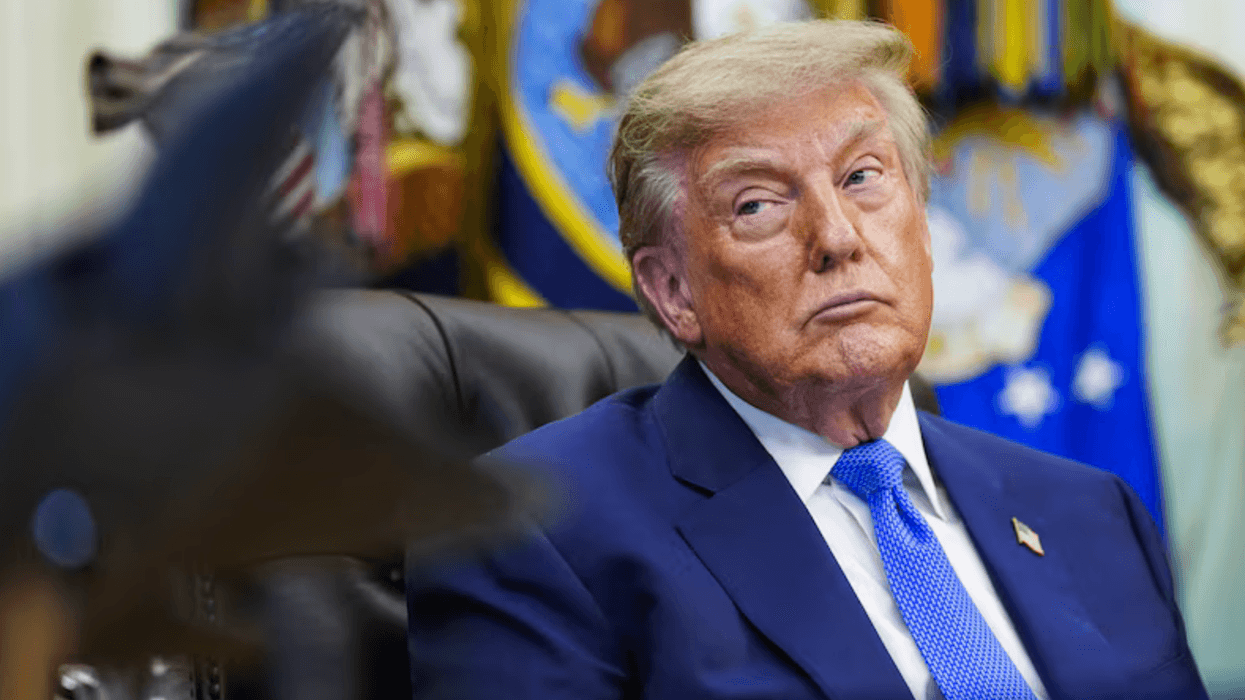 Donald Trump, presidente de Estados Unidos, sentado en un despacho oficial con banderas de fondo