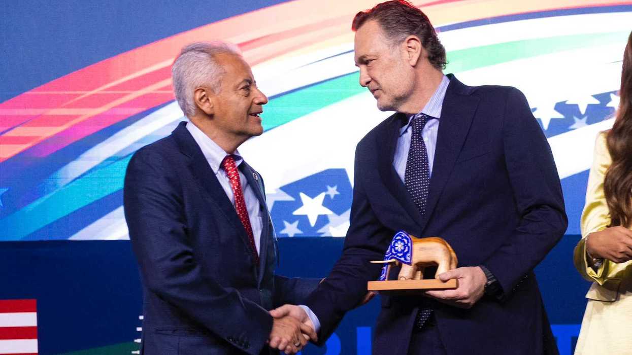 Dos asistentes se saludan en el escenario de la Convención Binacional México-Estados Unidos organizada por la AmSoc en Ciudad de México