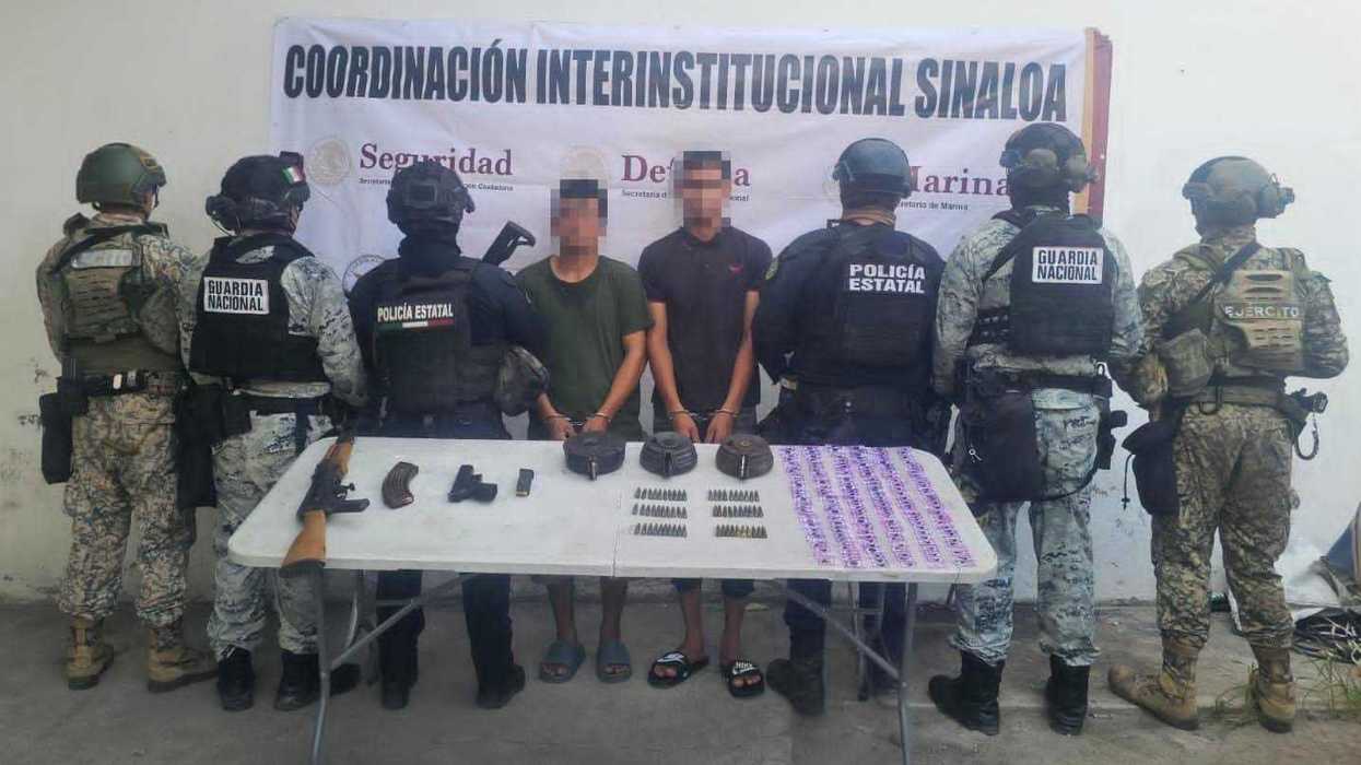 Dos detenidos con armas en Mazatlán ante una mesa con fusil AK-47, pistola, cargadores y dosis de presunta droga
