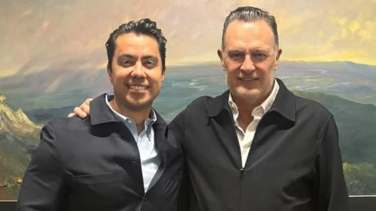 Dos hombres posan abrazados frente a una pintura de paisaje montañoso; la imagen acompaña la columna sobre la sucesión del PAN en Querétaro 2027.