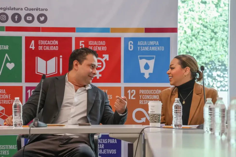 Dos integrantes de la comisi\u00f3n conversan en la mesa de trabajo antes de la sesi\u00f3n en el Congreso de Quer\u00e9taro.