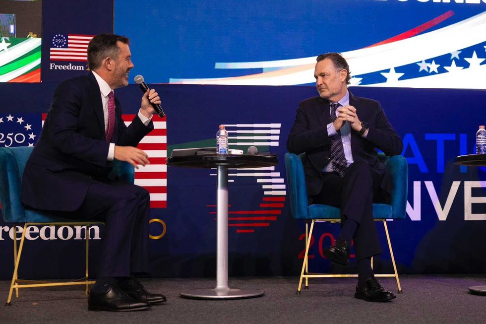 Dos participantes dialogan en el escenario de la Quinta Convenci\u00f3n Binacional M\u00e9xico-Estados Unidos, previo a la revisi\u00f3n del T-MEC