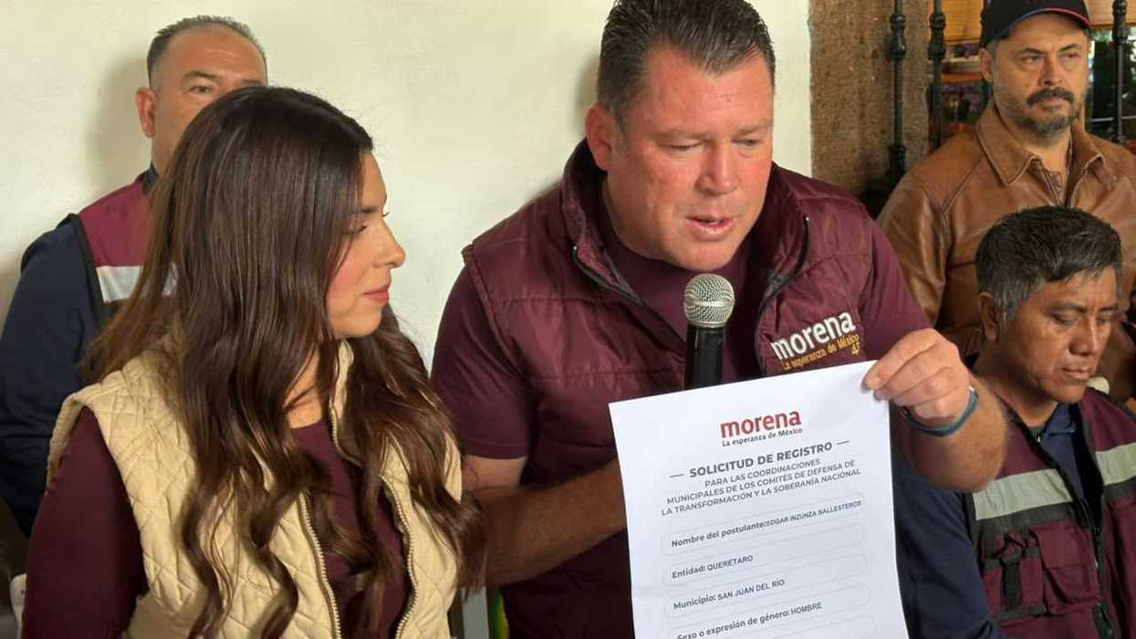 Edgar Inzunza Ballesteros muestra su solicitud de registro para la coordinación municipal de Morena en San Juan del Río durante una rueda de prensa.