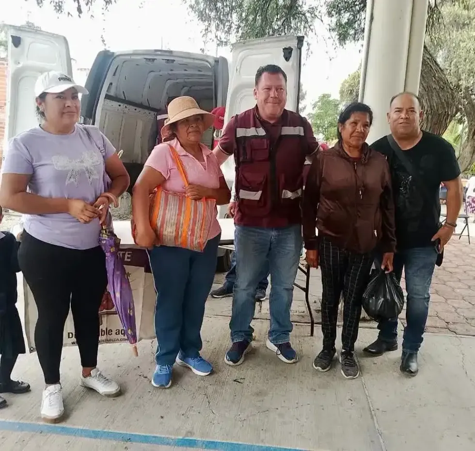 Edgar Inzunza posa con cuatro vecinos frente a una camioneta de carga