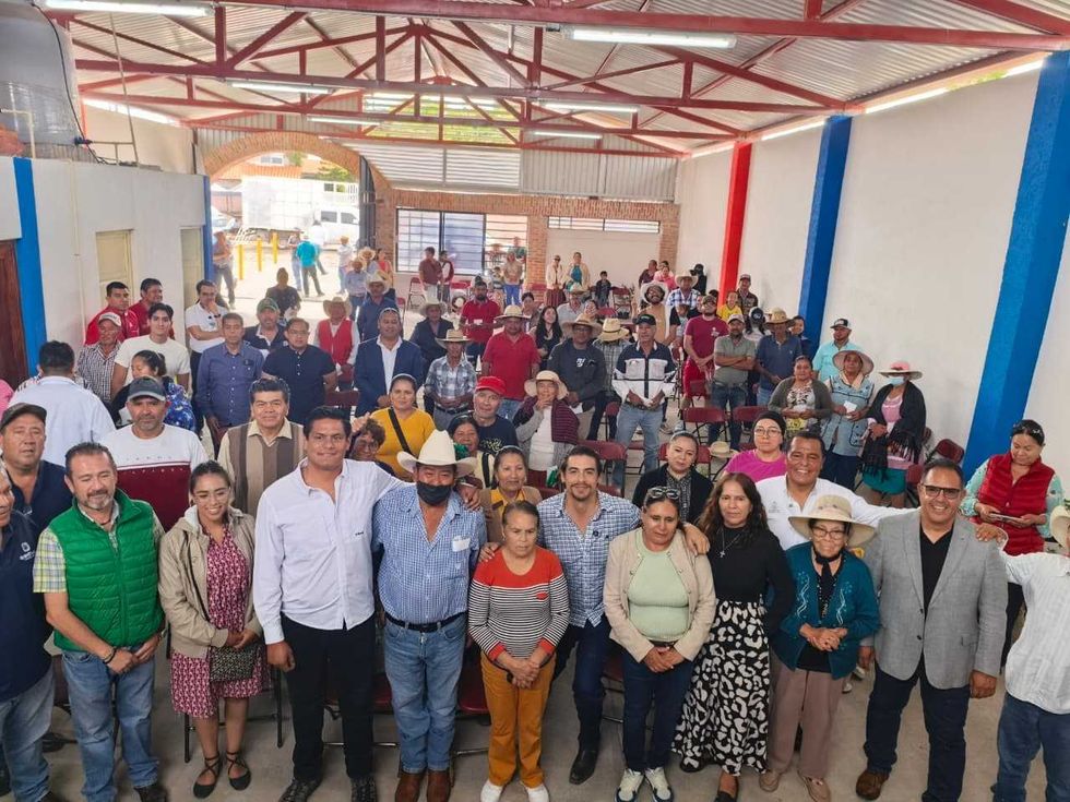 Ejidatarios, vecinos y funcionarios posan en el interior de la Casa Ejidal de La Tinaja