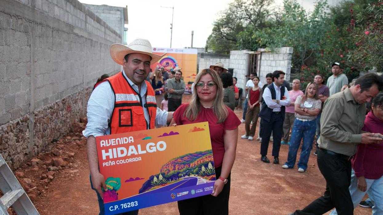 El alcalde de Colón entrega la placa de nomenclatura de la avenida Hidalgo a una vecina de Peña Colorada.