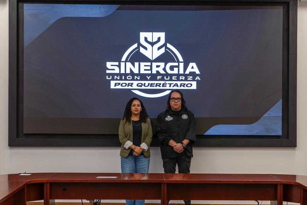El fiscal V\u00edctor Antonio De Jes\u00fas Hern\u00e1ndez y una funcionaria de Cadereyta de Montes frente a la pantalla con el logotipo de Sinergia por Quer\u00e9taro