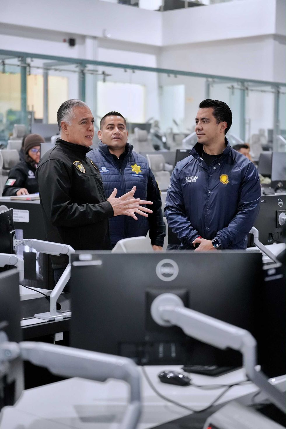 El presidente municipal de Quer\u00e9taro habla con personal de seguridad durante un recorrido por el CAE 911.