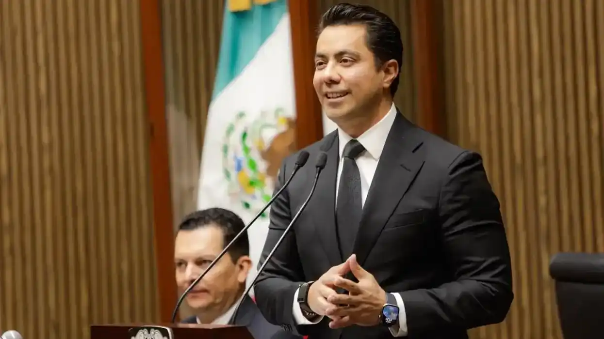 El presidente municipal de Querétaro dirige un mensaje desde la tribuna del salón de Cabildo, con la bandera nacional al fondo.