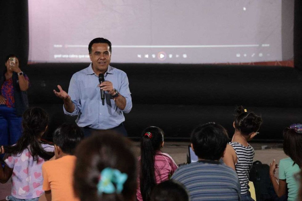 El secretario de Desarrollo Social Luis Nava habla con micr\u00f3fono durante la funci\u00f3n de cine comunitario de la estrategia Aqu\u00ed Contigo en San Juan del R\u00edo.