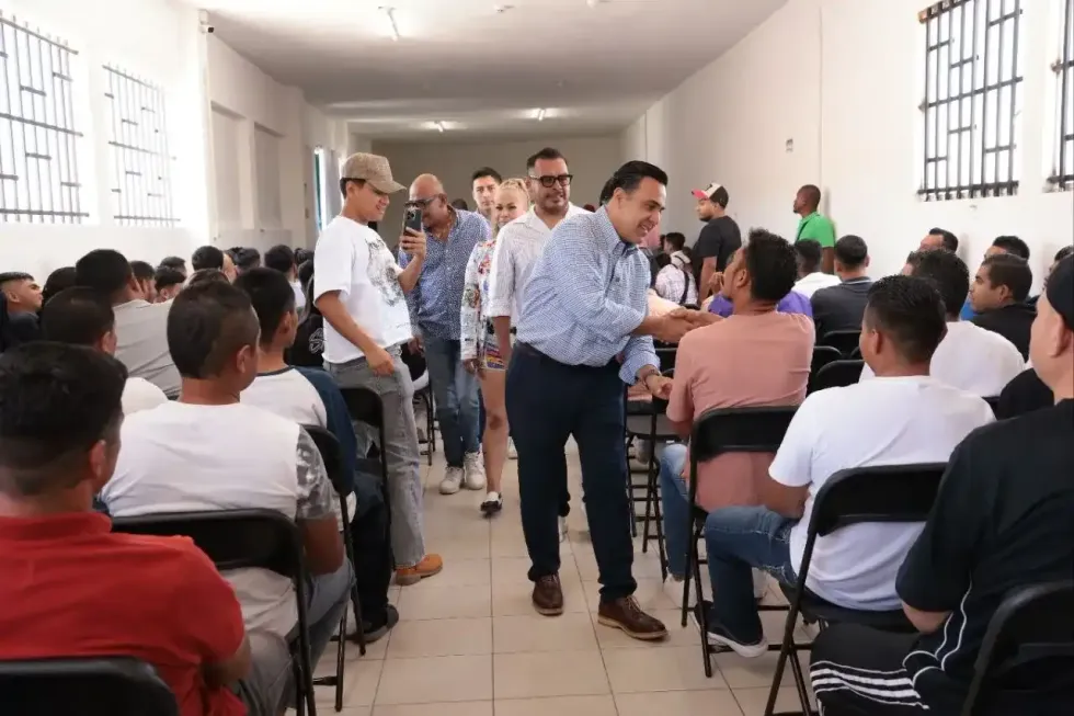 El secretario Luis Nava camina entre los asistentes durante la reuni\u00f3n con representantes de centros de tratamiento de adicciones en Quer\u00e9taro.