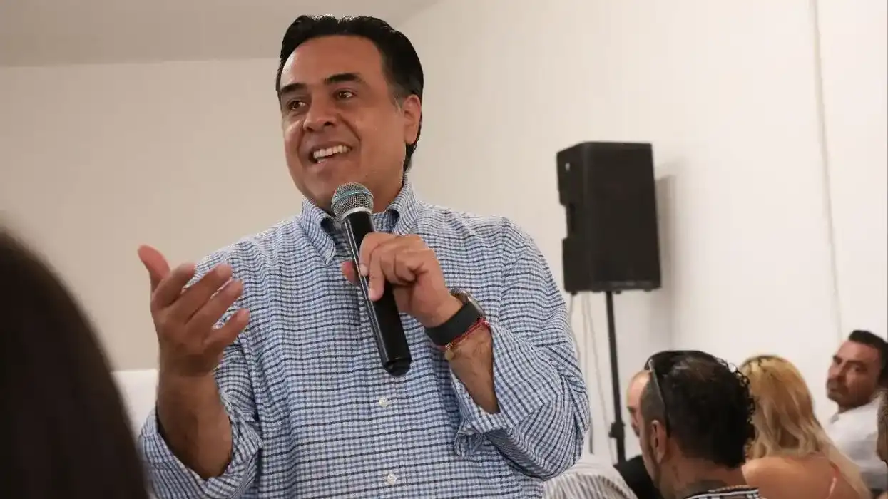 El secretario Luis Nava Guerrero habla con micrófono en mano durante la reunión con representantes de centros de tratamiento de adicciones en Querétaro.