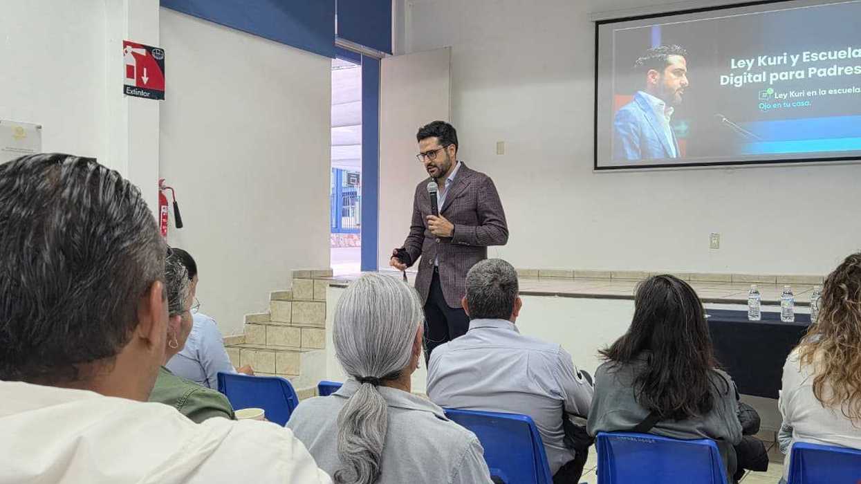 El senador Agustín Dorantes Lámbarri habla con micrófono ante padres de familia durante un taller sobre la Ley Kuri en Querétaro.