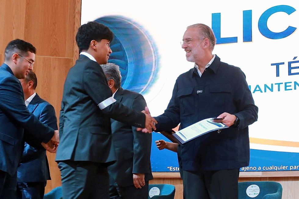 El titular de la SEDESU, Marco Antonio Del Prete Tercero, entrega una constancia a un egresado del CONALEP Aeron\u00e1utico durante la ceremonia de licencias en Quer\u00e9taro.