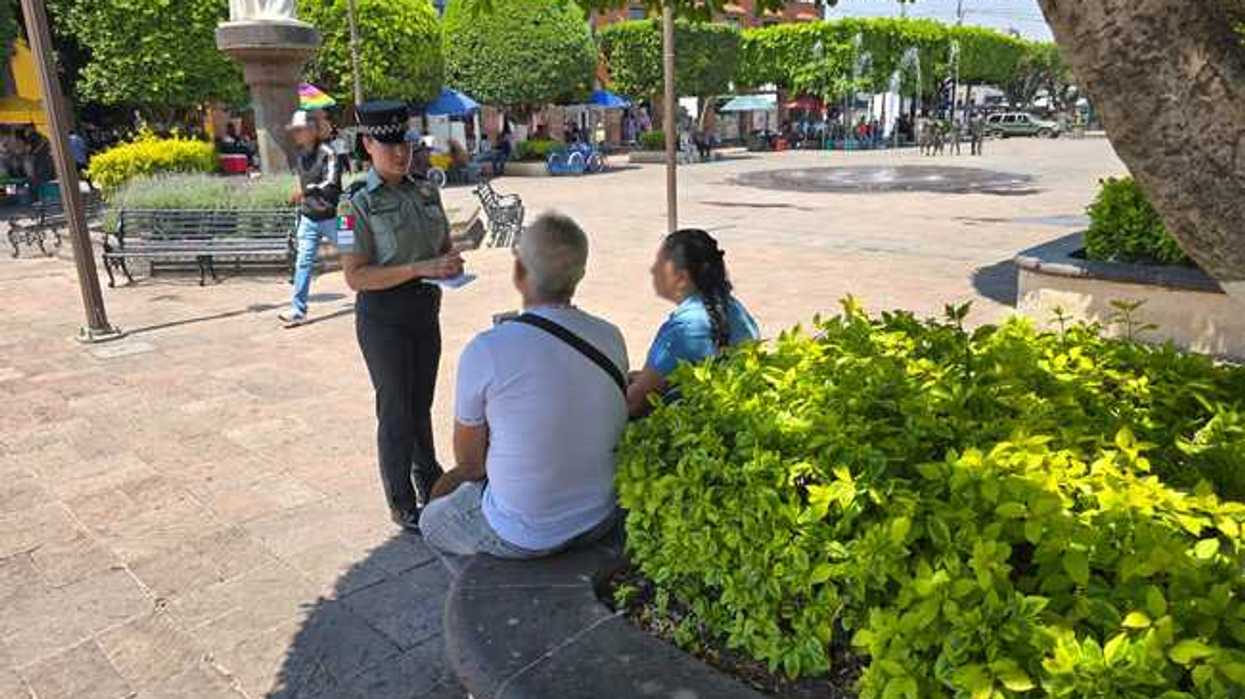 Elemento de la Guardia Nacional realiza labores de proximidad con ciudadanos en una plaza pública de San Juan del Río.