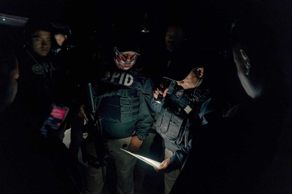 Elemento de la Polic\u00eda de Investigaci\u00f3n del Delito (PID) con casco t\u00e1ctico, visor y pasamonta\u00f1as, fotografiado en penumbra durante el operativo Sinergia