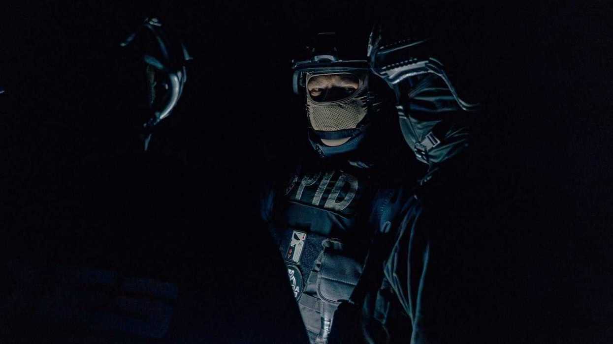 Elemento de la Policía de Investigación del Delito (PID) con casco táctico, visor y pasamontañas, fotografiado en penumbra durante el operativo Sinergia