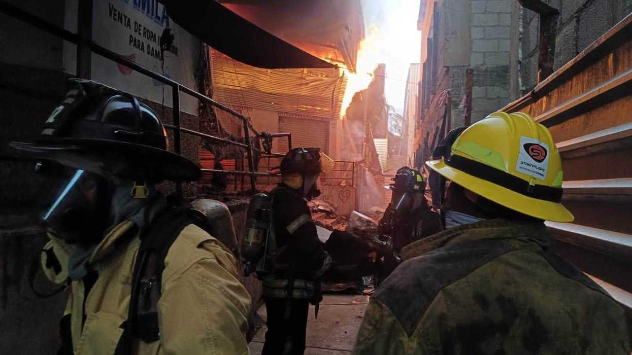 Elementos de bomberos con equipo de respiración autónoma frente a incendio activo en el Mercado Central de Acapulco