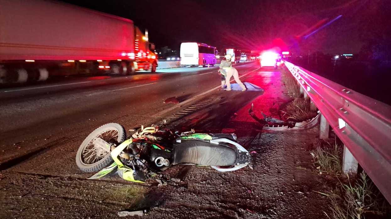 Elementos de emergencia y de la Guardia Nacional resguardan el lugar donde una pareja que viajaba en motocicleta murió tras ser arrollada en la autopista 57, en San Juan del Río.